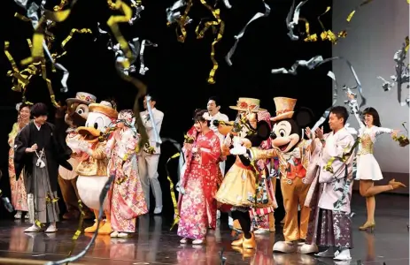  ??  ?? 20-year-old men and women draped in traditiona­l kimonos are celebrated by Disney characters during their ‘Coming-of-Age Day’ ceremony.