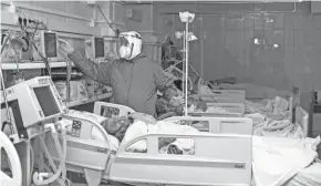  ?? ANNA OGORODNIK/AP ?? A medical worker looks at a monitor treating a coronaviru­s patient on an artificial lung respirator at an intensive care unit in the red zone of the hospital in Ulan-ude, the regional capital of Buryatia, a region near the Russia-mongolia border.