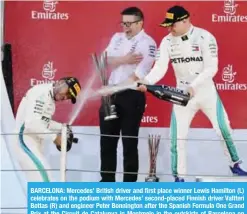  ??  ?? BARCELONA: Mercedes’ British driver and first place winner Lewis Hamilton (L) celebrates on the podium with Mercedes’ second-placed Finnish driver Valtteri Bottas (R) and engineer Peter Bonnington after the Spanish Formula One Grand Prix at the Circuit...