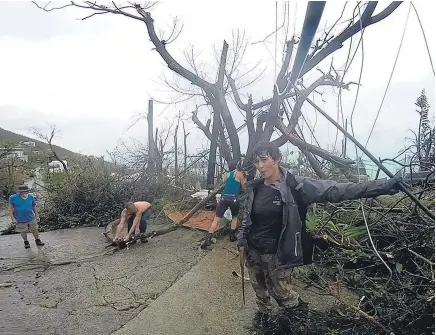  ?? Picture / AP ?? Residents were already out clearing the debris in St Thomas in the US Virgin Islands yesterday.