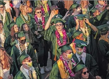  ?? Jay L. Clendenin Los Angeles Times ?? GRADUATES of Mira Costa High in Manhattan Beach after their drive- through ceremony in June. Propositio­n 18 would allow 17- year- olds to vote in primary elections if they turn 18 before the next general election.