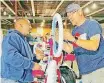  ?? [PHOTO BY CARLA HINTON, THE OKLAHOMAN ARCHIVES] ?? Kevin Mustin, of Oklahoma City, a line haul driver with FedEx, assembles a girls bicycle with fellow volunteer Steve Smathers, of Oklahoma City, during The Salvation Army’s 2017 “Buck$ 4 Bikes” bicycle assembly event in Oklahoma City.