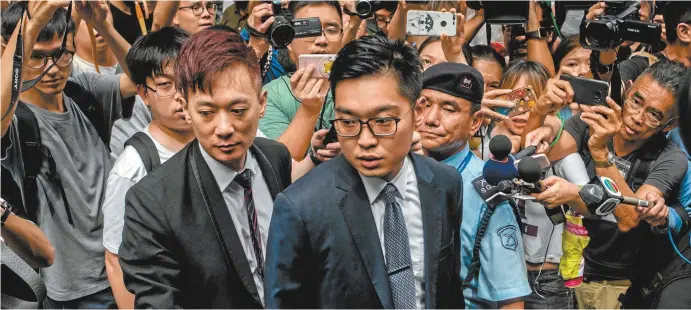  ??  ?? Andy Chan (centre), founder of the Hong Kong National Party, is surrounded by media as he leaves the Foreign Correspond­ents’ Club in Hong Kong in August.
