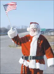  ?? BY TOM MCCALL/TMCCALL@CHESPUB.COM ?? A jolly Santa waves the American flag at drivers zooming over the Dover Bridge near Bethlehem. Santa was decked out his iconic red suit with some patriotic pins, military badges and a medal.
