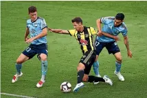  ?? GETTY IMAGES ?? Nathan Burns tries to squeeze his way between Sydney midfielder­s Brandon O’Neill and Anthony Caceres.
