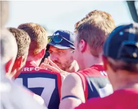  ??  ?? Koo wee rup coach Benjamin Collins urges his players to maintain momentum at the quarter time huddle following a strong start against Phillip Island on Saturday.
Right: Phillip Island’s Mark Griffin takes a strong mark over the pack despite the spoiling attempts of teammates and opposition alike.