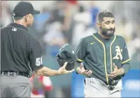  ?? TIM HEITMAN — USA TODAY SPORTS ?? Complying with new MLB protocols, A’s reliever Sergio Romo is checked for foreign substances by umpire Dan Iassogna on Tuesday.