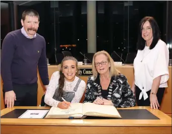  ??  ?? Lauren Cadden signs the Distinguis­hed Visitors Book with Mayor of Sligo Municipal District Cllr Rosaleen O’Grady and her parents Leonie and Michael at the Reception in County Hall. Pics: Carl Brennan.