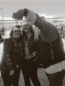  ?? Cary Clack / Staff ?? As a child, Louise Locker had faith in strangers — and her program that spreads Christmas joy proves her right. Left, a member of the Guardians of the Children snaps a photo with Elf Louise, center.