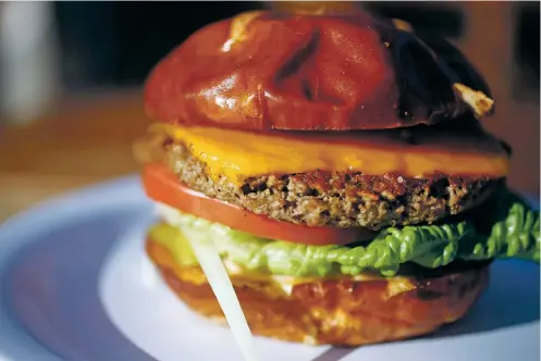 ??  ?? ABOVE: Root 66 serves the trendy and ecofriendl­y Impossible Burger — which looks, tastes and smells like beef but is made without animal products — with a nut-based cheese, pickles, lettuce, tomatoes, onions and special sauce.