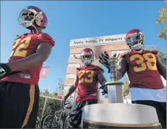  ?? Robert Gauthier
Los Angeles Times ?? USC’S Jahleel Pinner (38) touches a sword on the way to practice with teammates Justin Davis (22) and Tre Madden as training camp opens.