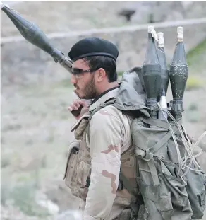  ??  ?? An Afghan soldier stands on the outskirts of Kabul, Afghanista­n. Some officials say at least 140 people were killed in an attack on a military compound in northern Afghanista­n on Friday. —AP PHOTO