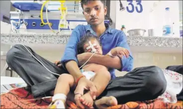  ?? DEEPAK GUPTA/HT ?? A relative attends to a sick child in the encephalit­is ward at BRD Medical College in Gorakhpur on Sunday.