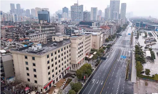  ??  ?? Ville fantôme.
Les avenues de Wuhan, mise en quarantain­e, sont quasiment désertes. La circulatio­n « non essentiell­e » y a été interdite.