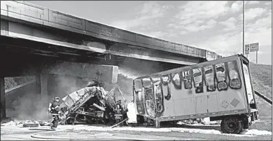  ?? Special to the Democrat-Gazette ?? Jonesboro firefighte­rs stand by after a tractor-trailer crashed into an overpass beam on Interstate 555 near Jonesboro on Tuesday in the photo from the Jonesboro Police Department. The highway officials are assessing the damage from the resulting fire...