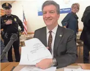  ?? MARK HOFFMAN / MILWAUKEE JOURNAL SENTINEL ?? Brad Courtney, chairman of the state electors’ meeting, displays the ballots for President-elect Donald Trump.