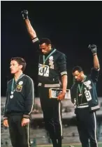  ??  ?? AP John Carlos (R) and Tommie Smith (C) make their protest on the podium at the 1968 Olympic Games in Mexico City.