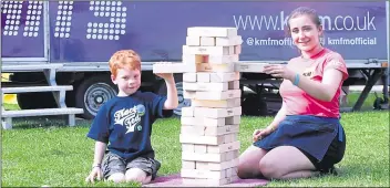  ??  ?? From left, Orson Anning, five and Alice Nobbs, KM Events Promotiona­l Employee play jenga