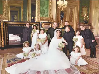  ?? AFP-Yonhap ?? This photo released by Kensington Palace Monday shows an official wedding photo of Britain’s Prince Harry and Meghan Markle, center, in Windsor Castle, Windsor, England, Saturday.