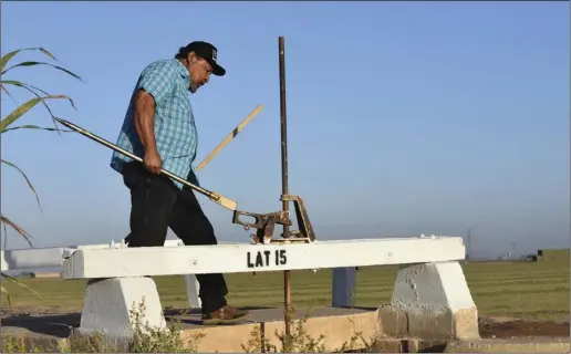  ?? PHOTO CHRIS MCDANIEL ?? Jose Romo, 64, of Holtville, has been a zanjero with IID for the past 43 years. He is seen here using a gate bar to open the mouth of Lateral 15 at the northwest intersecti­on of McCabe and Barbara Worth Roads. He used the large iron tool to open the water gate as his predecesso­rs would have done a century ago — by hand.