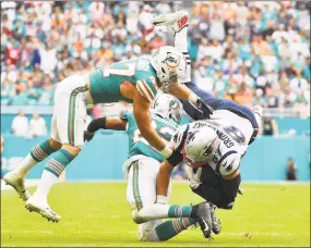  ?? Mark Brown / Getty Images ?? Patriots tight end Rob Gronkowski makes the catch against the Dolphins on Sunday at Hard Rock Stadium in Miami.