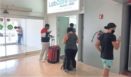  ?? PHOTOS BY DAWN GILBERTSON/USA TODAY ?? Travelers wait in line for a COVID-19 test at Cancun Internatio­nal Airport.