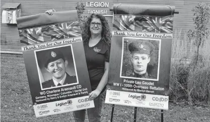  ?? ERIC MCCARTHY/JOURNAL PIONEER ?? Stephanie Kinch, a co-ordinator of the Tignish Legion’s Remembranc­e Banner Project, displays two of the 76 banners that will be suspended from posts around the legion parking lot until after Remembranc­e Day.