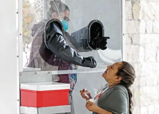  ?? TomReel / Staff photograph­er ?? Technician Melanie Florez of BexarAid takes a sample for a COVID-19 test. BexarAid offers the testing to individual­s and businesses.