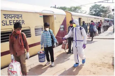  ?? PHOTO: PTI ?? A health worker sanitises migrants, who arrived from Jaipur in a Shramik Special train, at Danapur junction near Patna. JD(U) leader and Bihar CM Nitish Kumar was earlier opposed to the idea of bringing labourers back to their home states