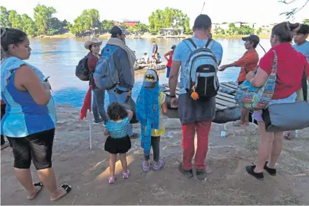  ?? ORLANDO SIERRA / AFP ?? STOKING FEAR: Honduran migrants prepare to board a makeshift raft to cross the Suchiate River yesterday and join a caravan heading to the U.S.