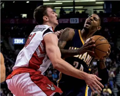  ??  ?? Indiana Pacers' Paul George, right, drives into Toronto Raptors' Tyler Hansbrough during the second half of an NBA basketball game in Toronto. The Raptors won 95-82.