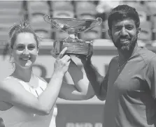  ?? DAVID VINCENT/THE ASSOCIATED PRESS ?? Gabriela Dabrowski, a native of Ottawa, and India’s Rohan Bopanna show off the trophy after winning the mixed doubles title at the French Open on Thursday in Paris.