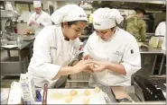  ??  ?? Culinary students Gabby Peralta, 11th grade, left, and Paola Trevino-Castro, 10th grade, attempt to convert army rations to more edible fare March 13 during the Army National Guard Chopped competitio­n at Berks Career & Technology Center East Campus in Oley Township. Eight two-member teams competed.