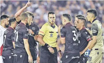  ??  ?? COPA LIBERTADOR­ES ► Jugadores de Lanús reclamándo­le en masa al colombiano Wilmar Roldán.