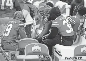  ?? ADAM CAIRNS/COLUMBUS DISPATCH ?? After leaving the game against Indiana with an injury, Ohio State running back Miyan Williams, middle, sits with fellow running backs, from left, Chip Trayanum, Evan Pryor, Treveyon Henderson and Dallan Hayden.