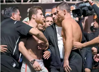  ?? AP ?? Canelo (izq.) es sujetado tras el altercado con Golovkin tras el pesaje de ambos.