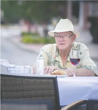  ?? DAX MELMER ?? Doug Zozad enjoys a glass of wine Saturday while sitting at his table set up on the road at Mezzo Ristorante & Lounge as more patio space was created by closing Erie Street. On Monday, Windsor-essex region learned it would remain in Stage 2 of reopening protocols while most of the province moved to Stage 3.