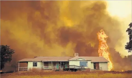  ?? Justin Sullivan Getty Images ?? FLAMES from the Detwiler fire approach a home in Mariposa, Calif. More evacuation orders were lifted Saturday night, officials said.