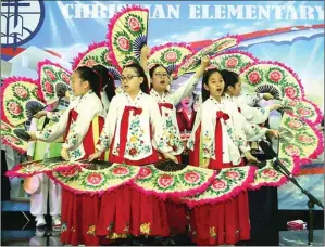  ?? ARYA DHITYA/JAWA POS ?? TARI KIPAS: Para siswi Central Christian Academy Suwon, Korea Selatan, menampilka­n tari buchaechum.