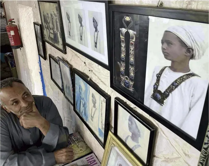  ?? Yomiuri Shimbun photos ?? Nubi, son of Hussein Abd el-Rassul, looks at the photograph of his father wearing a necklace from Tutankhamu­n’s tomb on the wall of his restaurant on Oct. 30.