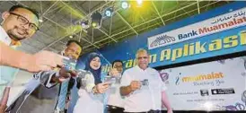  ?? SHAHRIZAL MD NOOR
PIC BY ?? Bank Muamalat chief executive officer Datuk Mohd Redza Shah Abdul Wahid (right) and his officers showing the MyDebit card for teachers and students in Langkawi yesterday.