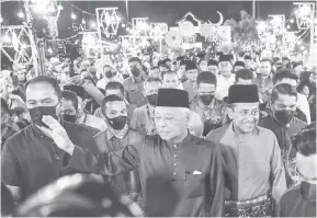  ?? — Gambar Bernama ?? BERJIWA RAKYAT: Ismail Sabri (tengah) melambaika­n tangan kepada orang ramai semasa hadir pada Majlis Rumah Terbuka Malaysia Aidilfitri 2022 di Dataran Drawbridge malam kelmarin.