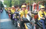  ?? LI JUNSHENG / FOR CHINA DAILY ?? Several dozen delivery men ride down a street in Kaifeng, Henan