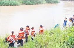  ?? ?? TUNGGU GILIRAN: Murid SK Dandun menunggu giliran menaiki perahu selepas tamat sekolah.