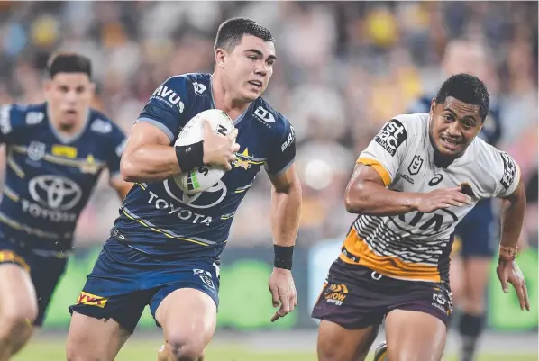  ??  ?? Cowboys halfback Jake Clifford charges past Broncos five-eighth Anthony Milford during his side’s win on Saturday night. Picture: Getty Images