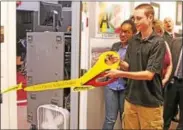  ?? CHRIS BARBER — DIGITAL FIRST MEDIA ?? Jake Zebley cuts the ribbon at the door of the new Avon Grove High School TV station.