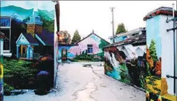  ?? PHOTOS BY XU ZHENYU AND GUO JUN / FOR CHINA DAILY ?? From top: Tourists pose for photos with an elephant and a giraffe that were painted on the walls of houses in Guazhou village, Yangzhou, Jiangsu province. Above: Outside walls in the village are decorated with colorful paintings.