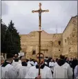  ?? LEO CORREA — THE ASSOCIATED PRESS ?? Catholic clergy walk in procession next to the Church of the Nativity, traditiona­lly believed to be the birthplace of Jesus, on Christmas Eve, in the West Bank city of Bethlehem on Sunday.