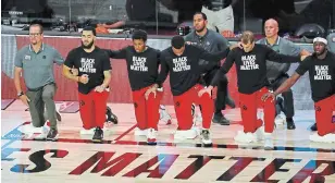  ?? KIM KLEMENT THE ASSOCIATED PRESS FILE PHOTO ?? The Toronto Raptors kneel during the national anthem before Game 3 of an NBA first-round playoff series in August. It was one of many images of athlete activism during 2020.