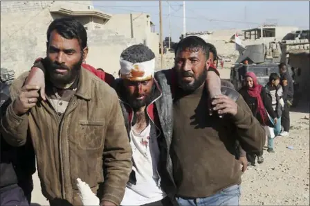  ?? KHALID MOHAMMED — THE ASSOCIATED PRESS ?? A man injured during fighting between Iraqi security forces and Islamic State militants is taken to a hospital as displaced people flee their homes Saturday in the Mamun neighborho­od in the embattled western part of Mosul, Iraq.